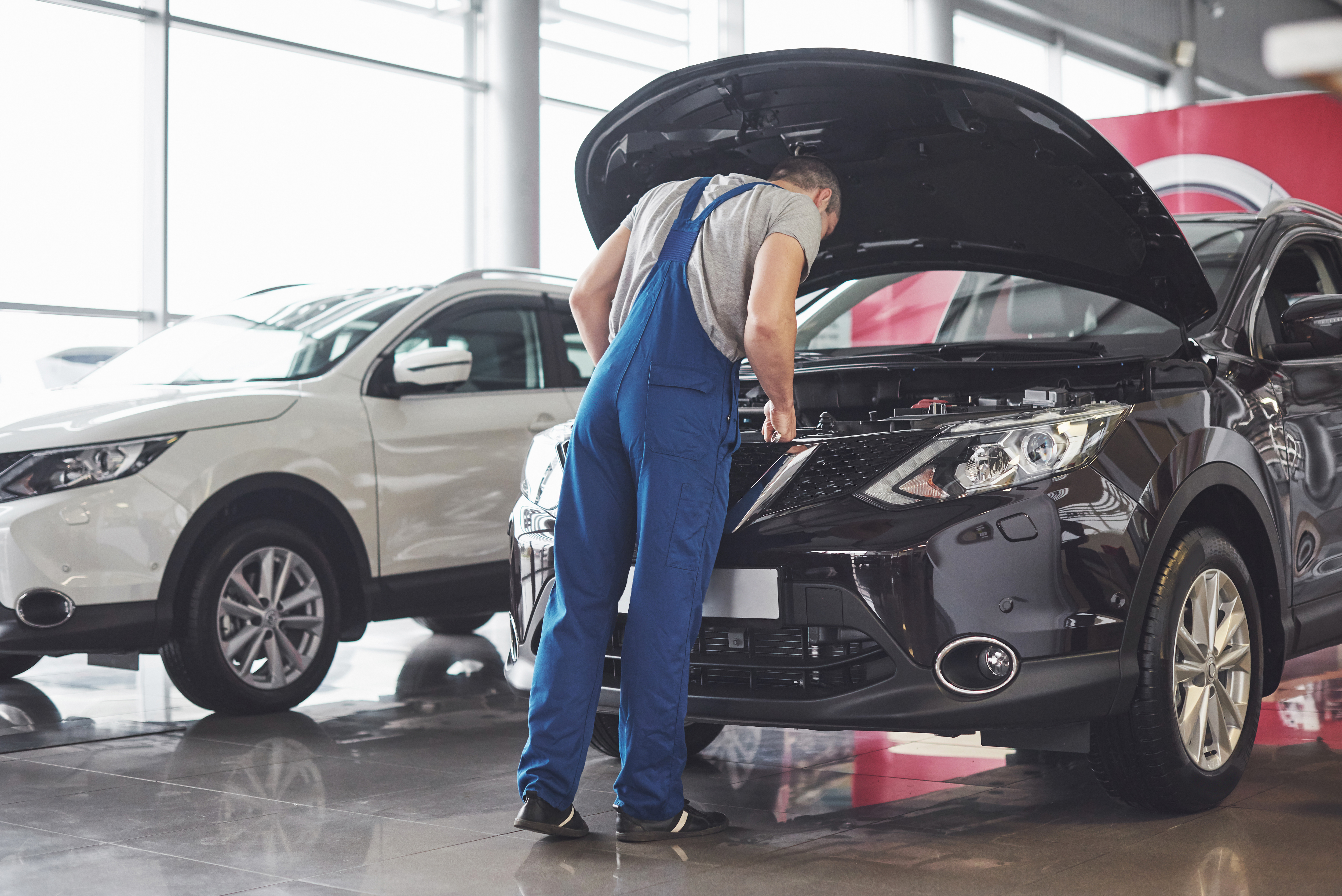 Technician checking vehicle under open hood